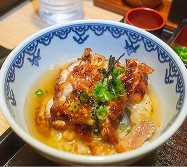 「鰻魚飯三吃」的原味炭烤鰻魚飯加入蔥花和海苔後加入了高湯,即為茶泡飯。